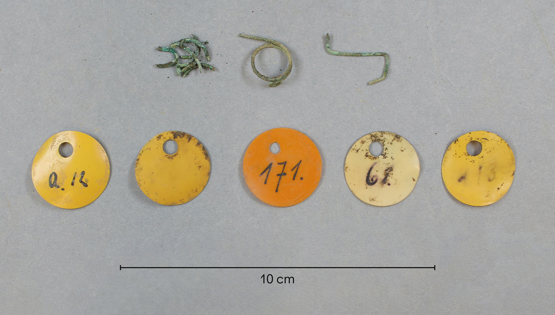 The picture shows three metal hooks and five round tags. The tags are two and one half centimeters in diameter and are labeled with numbers.