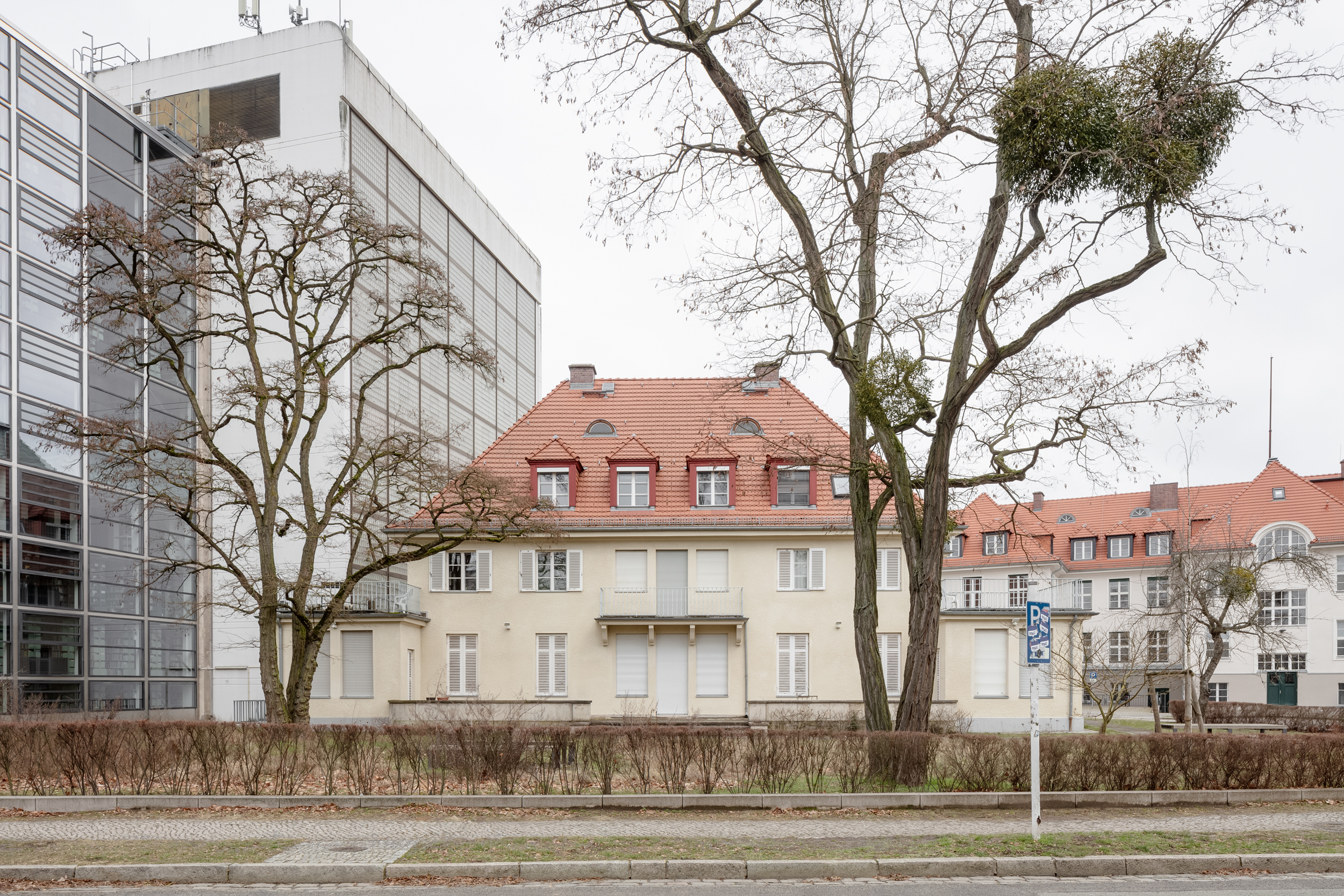 Foto aus dem Jahr 2024, auf dem sich das Gebäude der ehemaligen Direktorenvilla befindet. Es wird von dem links von dem Gebäude stehenden Magazinturm der Universitätsbibliothek überragt.